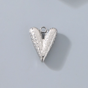 Macro di un ciondolo a cuore in acciaio inossidabile argento con finitura martellata unica