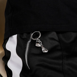 Detail of silver boxing glove keychains attached to a black zipper for a sporty look