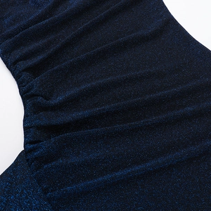 Détail macro du tissu scintillant bleu marine avec d'élégants froncements sur le côté