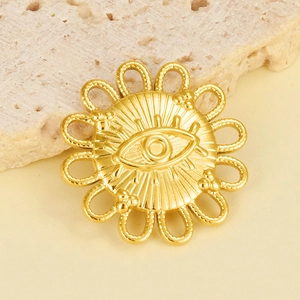 Macro shot of gold-plated stainless steel evil eye sunburst pendant on stone surface
