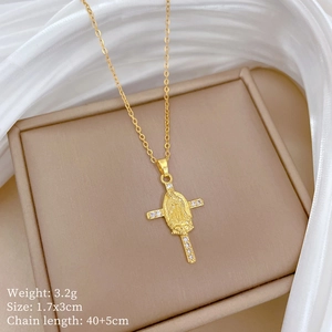 Macro detail of gold plated cross pendant with Virgin Mary engraving and small crystals
