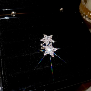 Macro shot of silver star ear cuff with sparkling cubic zirconia crystals on black background