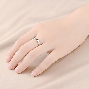 Detalle de cerca de un anillo minimalista de acero de titanio llevado en un dedo
