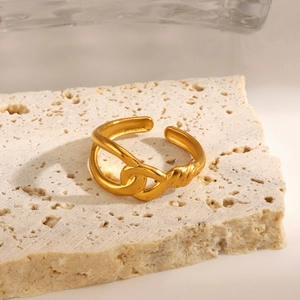 Minimalist gold-plated stainless steel intertwined ring on a natural stone base