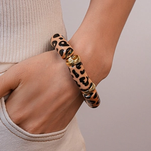 Close-up of leopard print beaded bracelet with gold spacers on a model's wrist