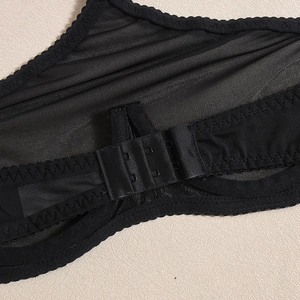 Macro shot of black mesh lingerie back closure with two-row hook and eye fastener