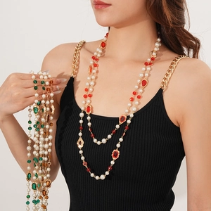 Detail of vintage multi-layer pearl necklace with colorful gemstones and gold chain links