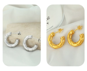 Detail von C-förmigen Metallohrringen mit Rautenmuster in Gold und Silber Ausführung