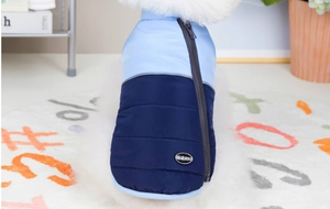 Detailed close-up of a blue two-tone padded pet vest with zipper and logo tag