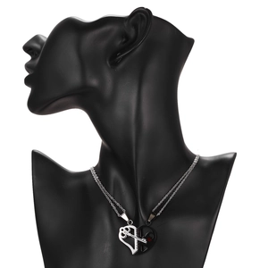 Macro detail of puzzle heart couple necklace with key and lock elements in silver and black