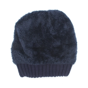 Detailed texture of navy blue thick faux fur and ribbed knit cuff on winter beanie