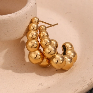 Macro view of 18K gold-plated beaded C-shape earrings with a polished mirror finish