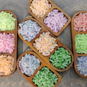 Macro view of colorful bamboo-shaped glass beads in vintage wooden trays for DIY jewelry