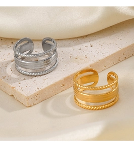 Detail of multi-layer 18K gold and silver rings with braided texture on silk fabric