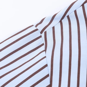 Détail de la couture fine et de la texture du tissu en coton popeline à rayures bleues