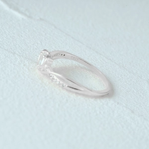 Close-up of S925 sterling silver heart ring with twisted band and micro-inlaid diamonds