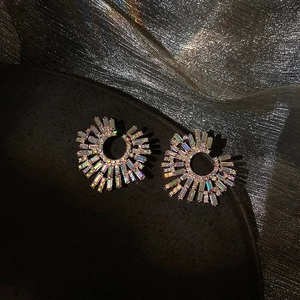 Detailed close-up of fan-shaped earrings with colorful AB crystals on a silver fabric