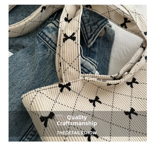 Macro di una borsa tote in velluto a coste bianco crema con motivi a fiocco neri