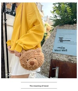 Brown plush bear head crossbody bag styled on a model with casual outfit and yellow hoodie