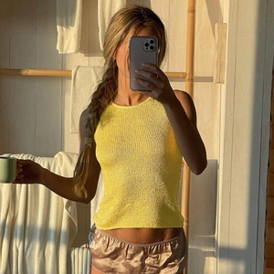 Close-up of yellow sleeveless knit top showing ribbed texture and cropped cut detail