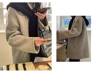 Detail of herringbone pattern wool coat paired with a warm integrated neck scarf
