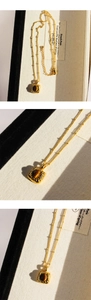 Detail of vintage gold necklace featuring square tiger eye stone pendant and beaded chain