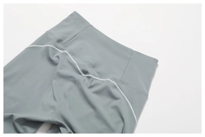 Detail of high waisted yoga leggings with stylish white contrast stitching in grey blue