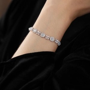 Détail d'un bracelet argenté avec pierres d'opale carrées et maillons fleurs en zircon