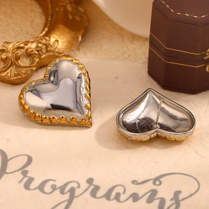 Exaggerated heart earrings in silver and gold two-tone finish for a retro luxury style