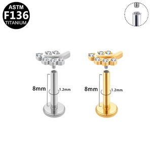 Detail of G23 titanium labret studs with leaf design in gold and silver finish, 8mm length