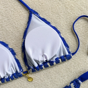 Texture tricotée détaillée du bikini bleu roi avec breloque coquillage et coussinets
