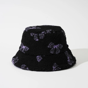 Close-up of winter bucket hat with lamb wool texture and purple butterfly jacquard details
