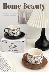 Close-up of vintage ceramic coffee cup set with forest reindeer pattern in gift box