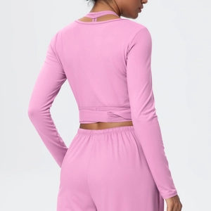 Detailed back view of pink long sleeve sports top featuring crisscross tie waist and soft fabric