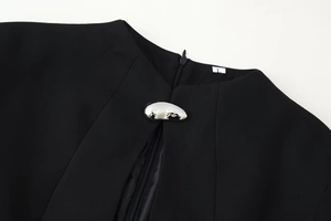 Detail of black stand collar dress with textured fabric and a silver metal buckle