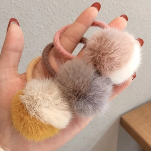 Dettaglio ravvicinato di elastici per capelli in peluche rosa, grigio e giallo