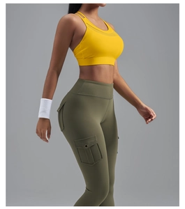 Détail de la brassière de sport jaune à bretelles croisées et du legging cargo olive