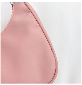 Close-up of pink nylon crossbody bag showing smooth fabric texture and silver zipper detail