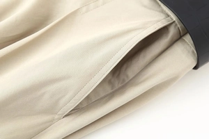 Detail view of khaki twill fabric dress showing pocket opening and reinforced stitching