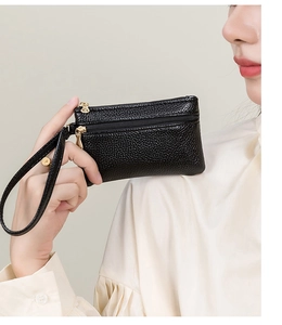 Close-up of black litchi grain leather double zipper coin purse with gold hardware