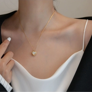 Elegant gold heart pendant necklace with white shell inlay and vintage floral edge