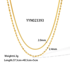 Detail of gold double-layer necklace featuring snake and bead chains on white background