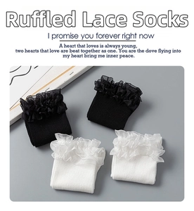 Detail of double-layer organza lace cuffs on ribbed cotton knee-high socks in black and white
