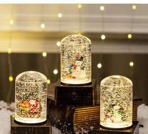 Detailed view of three vintage Christmas snow globes with Santa and snowman scenes