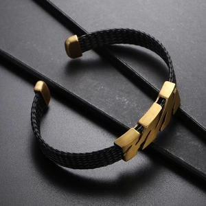 Détail du bracelet tressé noir pour homme avec accents en métal doré brossé
