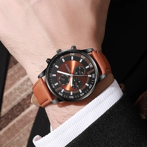Close-up of men business watch with brown sunray dial and genuine leather strap on wrist
