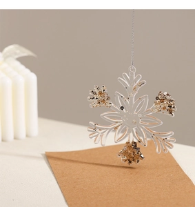 Close-up of clear acrylic snowflake ornament with gold and bronze glitter decoration