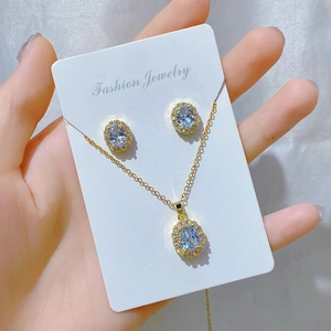 Detailed close-up of golden necklace and earrings set with oval blue gemstones