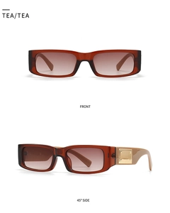 Detail of square sunglasses with amber frames and bold golden metal temples in tea color
