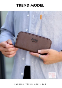 Brown leather long wallet for men held by hand showing grainy texture and zipper detail